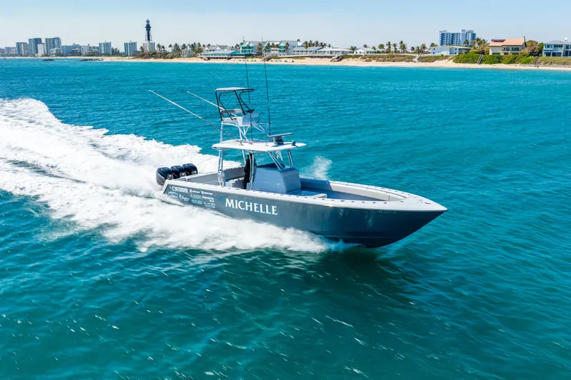  Yacht Photos Pics 2023 Contender 39ST boat cruising on blue ocean near coastline.