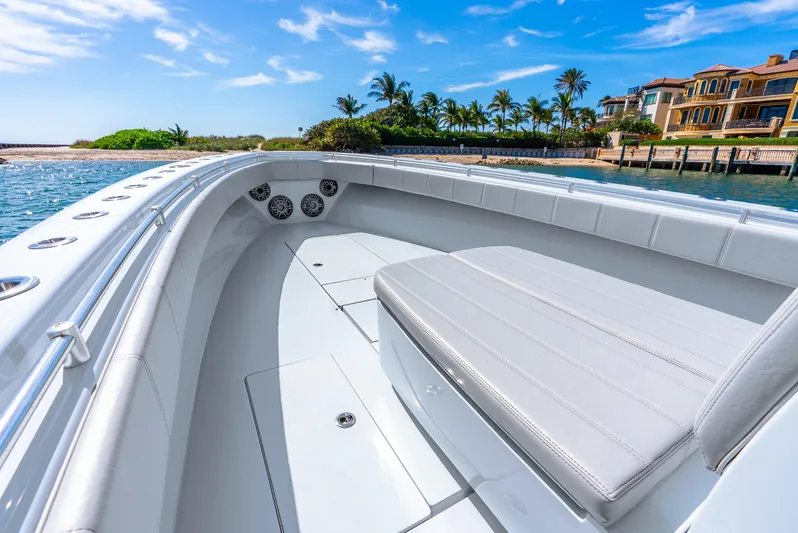  Yacht Photos Pics 2023 Contender 39ST boat with sleek seating, docked near luxury waterfront homes.