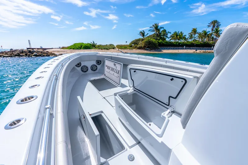  Yacht Photos Pics 2023 Contender 39ST boat interior with open storage, ocean view, and palm trees in the background.