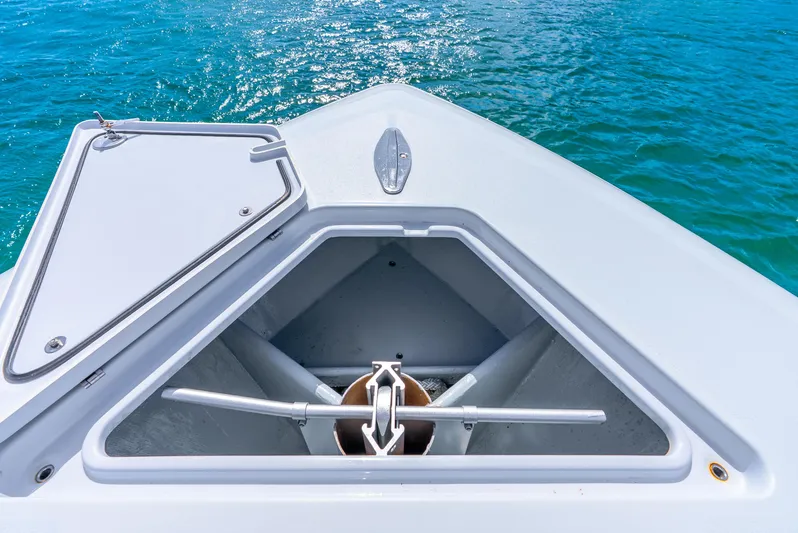  Yacht Photos Pics 2023 Contender 39ST boat anchor compartment with open hatch, floating on clear blue water.