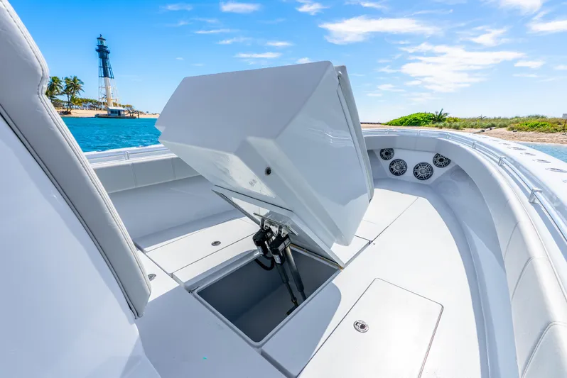  Yacht Photos Pics 2023 Contender 39ST boat with open storage compartment, near a lighthouse and ocean view.