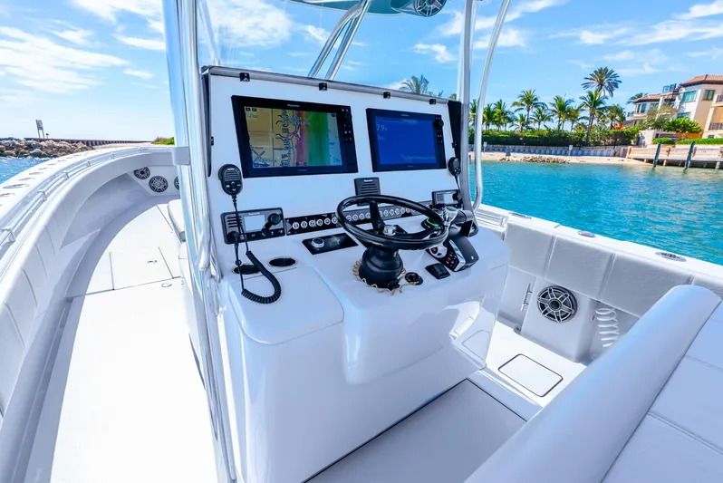  Yacht Photos Pics 2023 Contender 39ST boat cockpit with dual screens, steering wheel, and ocean view.