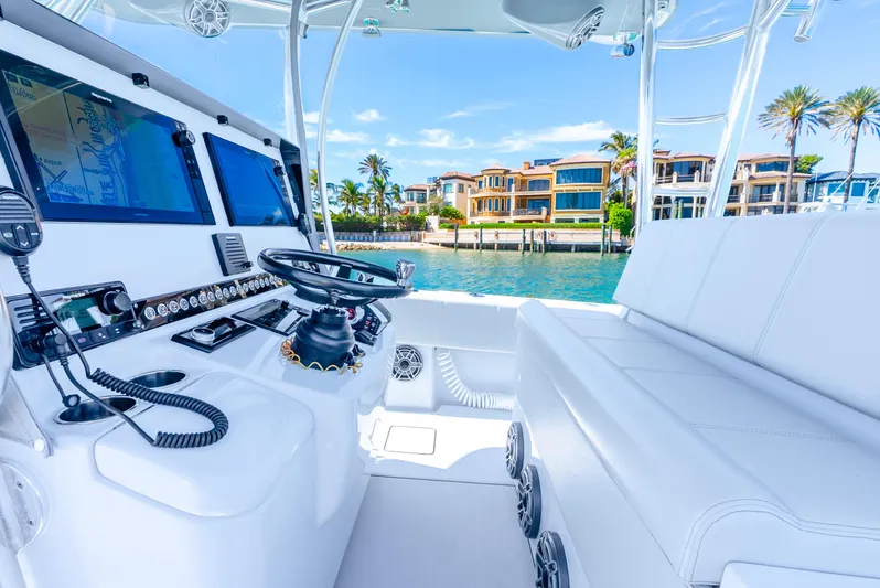  Yacht Photos Pics 2023 Contender 39ST boat interior with modern controls, luxurious seating, and waterfront view.