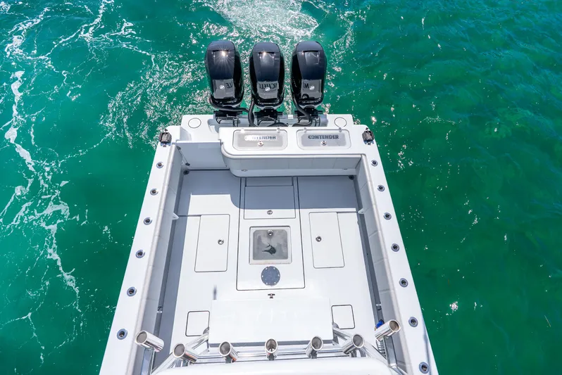  Yacht Photos Pics 2023 Contender 39ST boat with triple outboard engines on turquoise water.