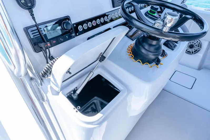  Yacht Photos Pics 2023 Contender 39ST boat console with steering wheel and storage compartment.