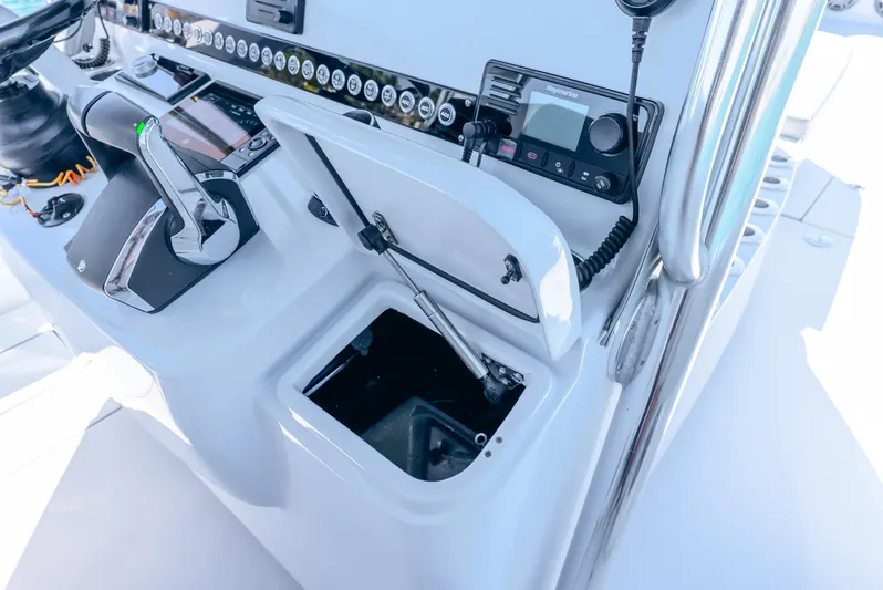  Yacht Photos Pics 2023 Contender 39ST boat console with open storage compartment and control panel.