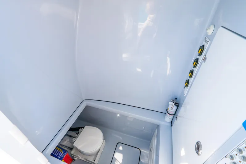  Yacht Photos Pics 2023 Contender 39ST boat interior with compact marine toilet and control panel.