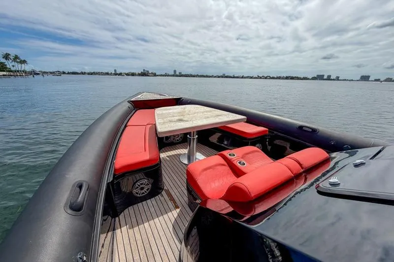  Yacht Photos Pics Luxurious 2023 Skipper-BSK 42NC boat with red seating and table on calm water.