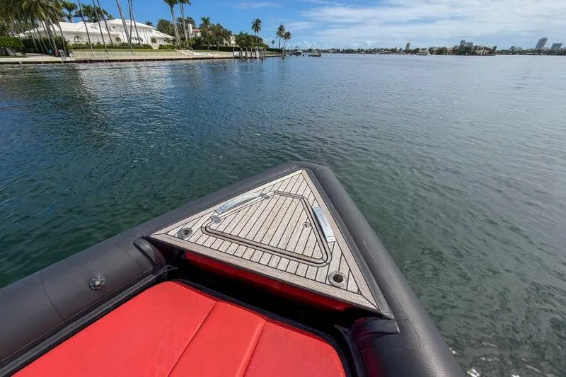  Yacht Photos Pics Bow of 2023 Skipper-BSK 42NC boat with red seating, on calm water.
