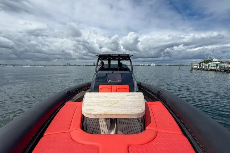  Yacht Photos Pics Luxury Skipper-BSK 42NC boat with red seating, 2023 model, on a calm waterway.