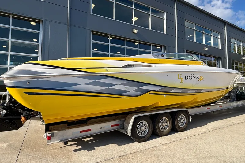 Yacht Photos Pics 2002 Donzi 45 ZX powerboat in vibrant yellow on a trailer outside a modern building.