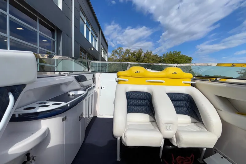  Yacht Photos Pics 2002 Donzi 45 ZX boat interior with white and yellow seating, docked near a modern building.