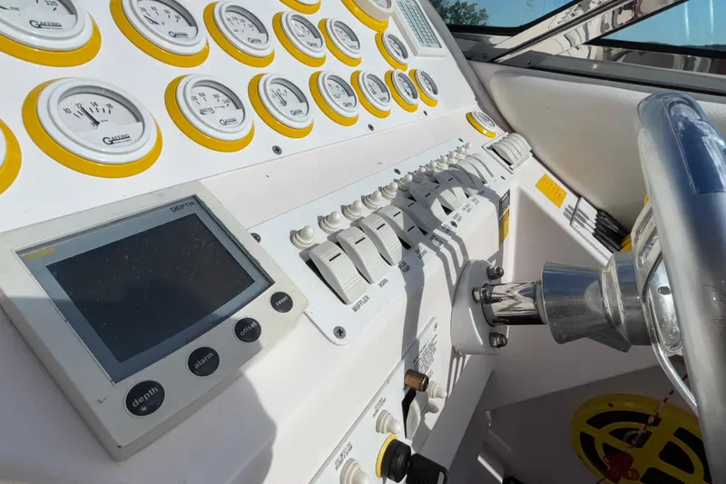  Yacht Photos Pics 2002 Donzi 45 ZX boat dashboard with gauges, switches, and steering wheel.