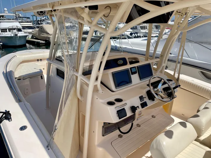  Yacht Photos Pics 2012 Grady-White Canyon 336 boat cockpit with dual screens and steering wheel at marina.
