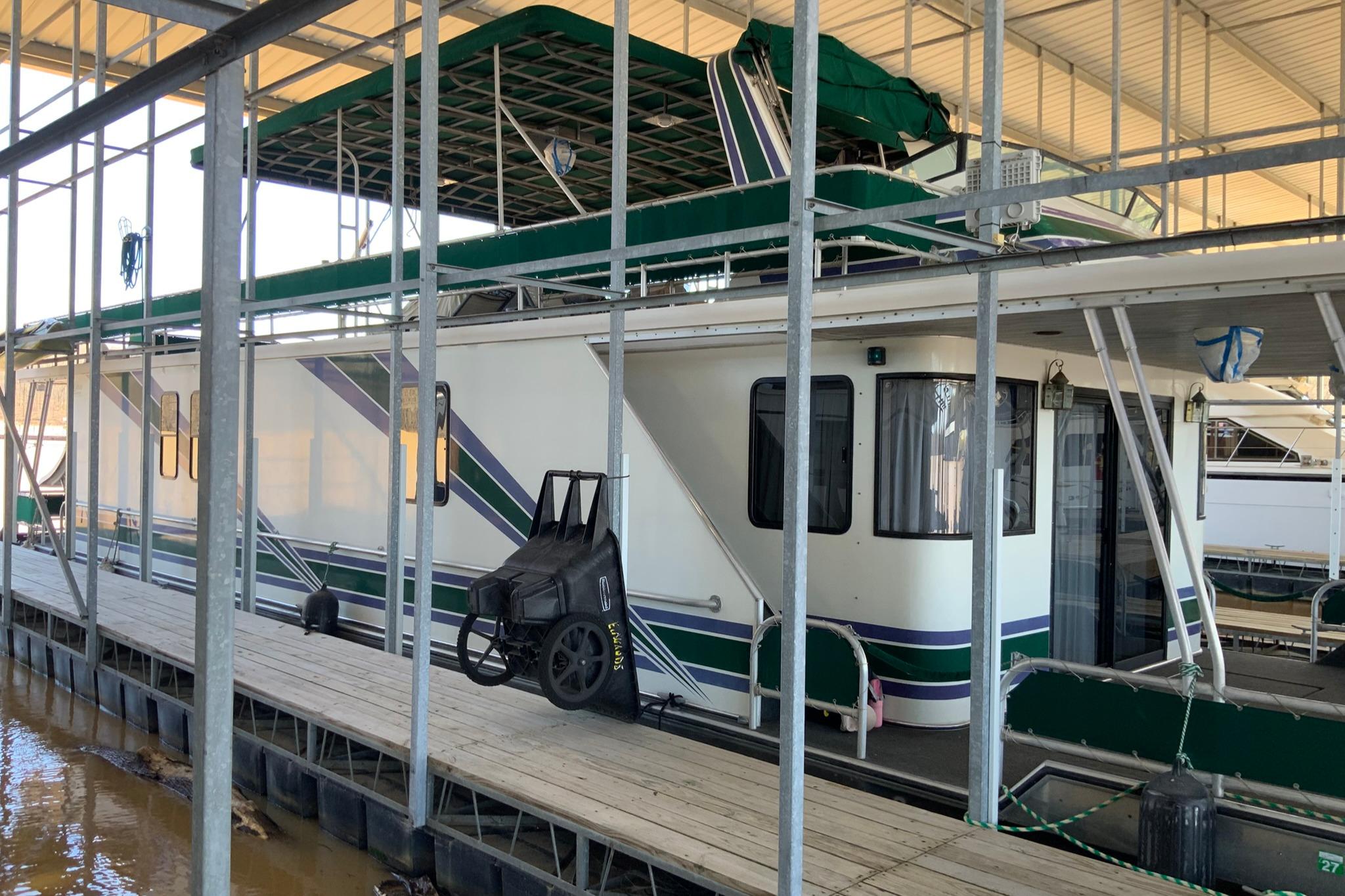 1997 Lakeview 16 x 65 houseboat docked under a covered marina.