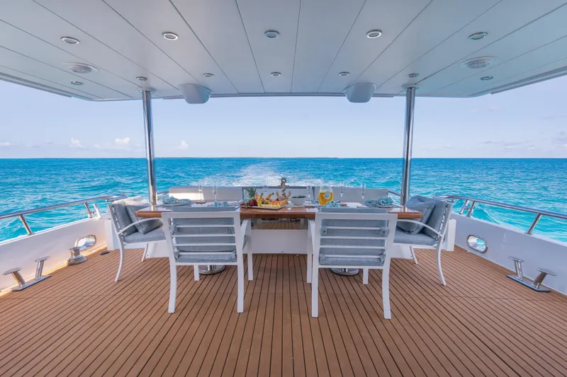 Two Seas Yacht Photos Pics Luxurious 2001 Hargrave Flybridge yacht deck with ocean view and elegant dining setup.