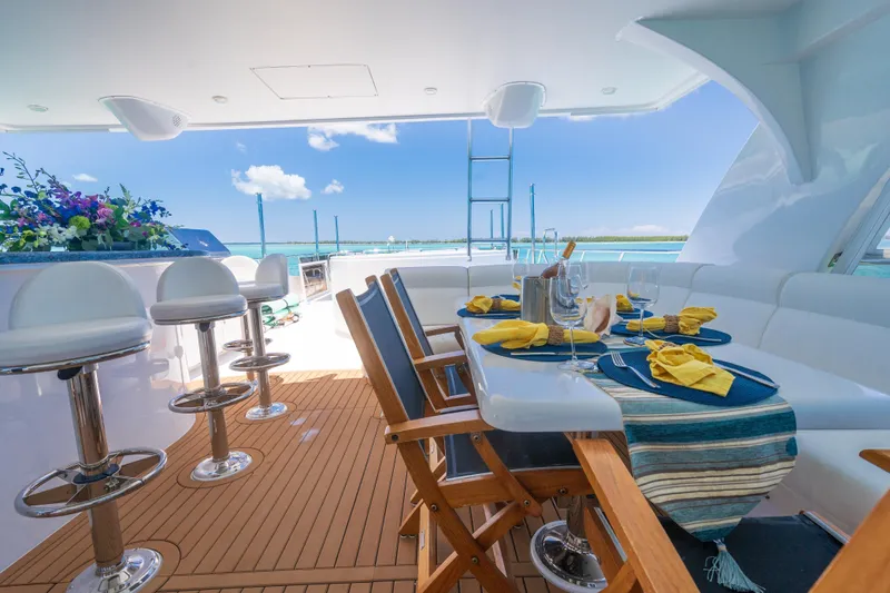 Two Seas Yacht Photos Pics Luxurious 2001 Hargrave Flybridge yacht with elegant outdoor dining setup and ocean view.