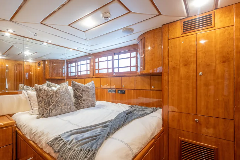 Two Seas Yacht Photos Pics Luxurious 2001 Hargrave Flybridge yacht bedroom with wood paneling and plush bedding.