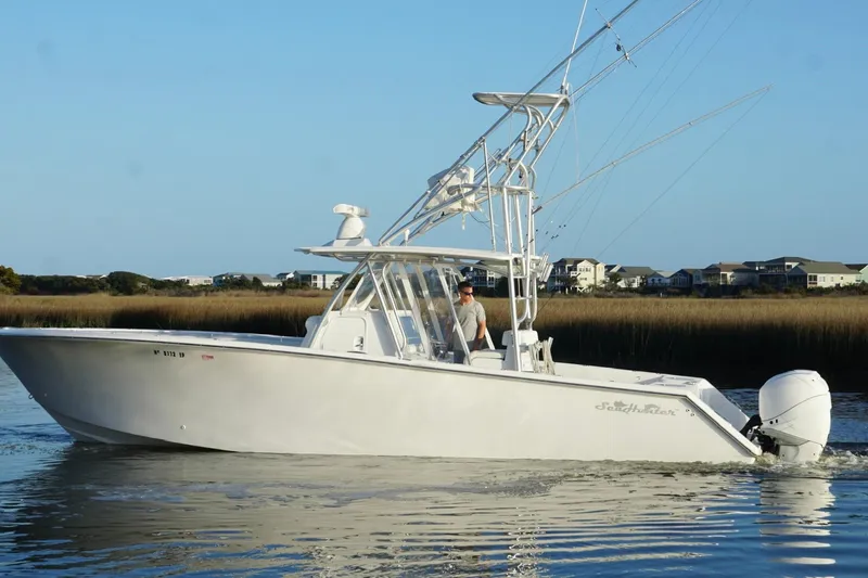  Yacht Photos Pics 2017 SeaHunter 35 Tournament boat cruising on calm water near coastal homes.