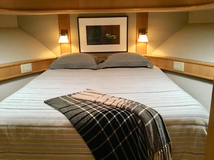 "southern Cross" Yacht Photos Pics Cozy bedroom in 1998 West Bay Sonship yacht with plaid blanket and wall art.