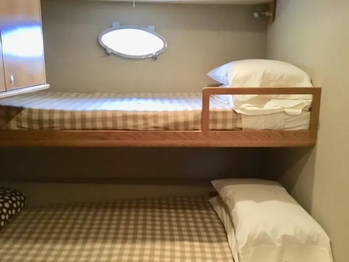 "southern Cross" Yacht Photos Pics Bunk beds in 1998 West Bay Sonship yacht cabin with checkered bedding and porthole window.