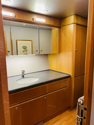 "southern Cross" Yacht Photos Pics Luxurious 1998 West Bay Sonship yacht bathroom with wood cabinetry and modern fixtures.