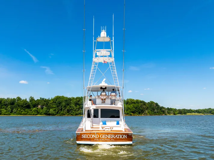 Second Generation Yacht Photos Pics 2006 Viking 68 Convertible yacht on water, clear sky, lush green shoreline.