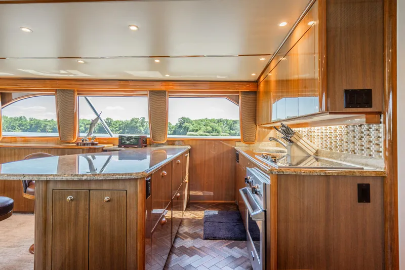 Second Generation Yacht Photos Pics Luxurious kitchen interior of 2006 Viking 68 Convertible yacht with wood cabinetry and scenic window view.