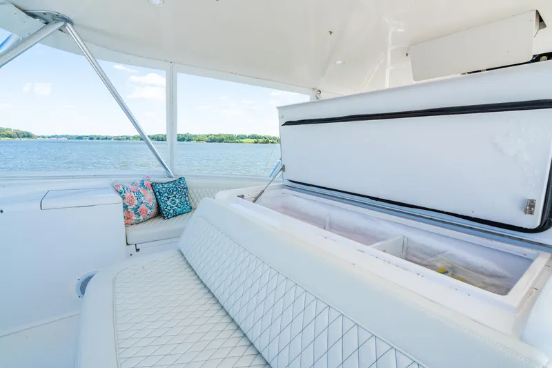 Second Generation Yacht Photos Pics Luxurious 2006 Viking 68 Convertible yacht interior with seating and open storage, overlooking serene water.