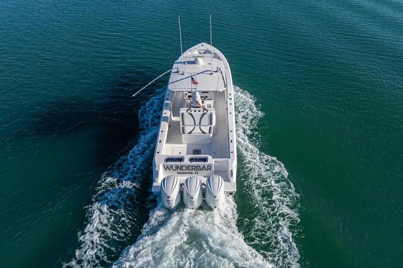 Wunderbar Yacht Photos Pics 2022 Contender 39 ST boat cruising on open water, rear view.