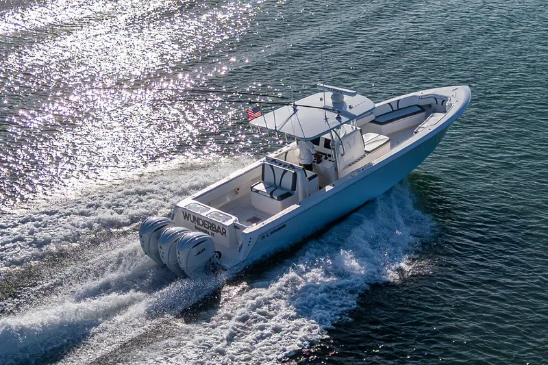 Wunderbar Yacht Photos Pics 2022 Contender 39 ST boat cruising on water, rear view with triple engines.