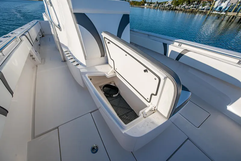 Wunderbar Yacht Photos Pics 2022 Contender 39 ST boat with open storage compartment on deck, near calm water.