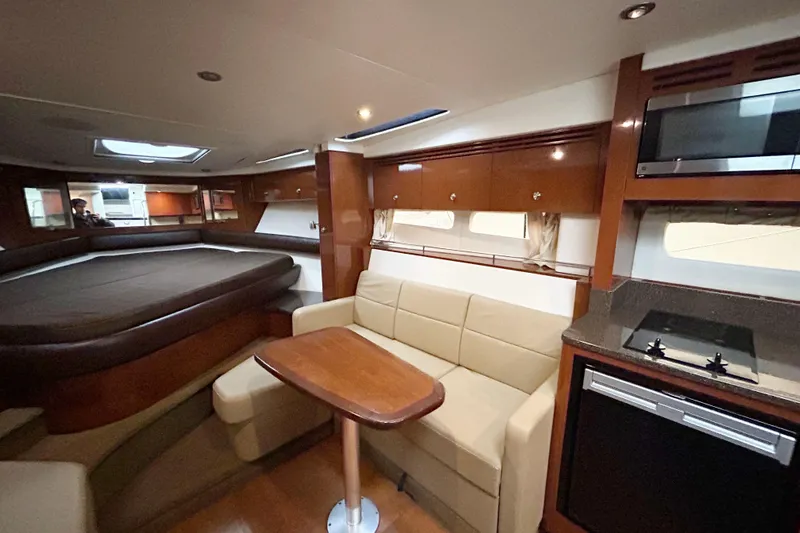  Yacht Photos Pics Interior of 2014 Sea Ray 350 Sundancer yacht with seating, table, and kitchenette.