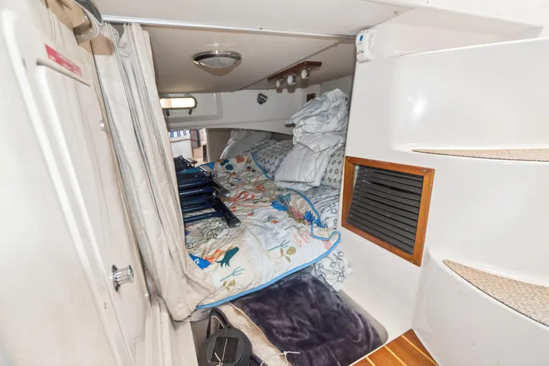 Pole Position Yacht Photos Pics Interior cabin of 2006 Grady-White Express 330 boat with bedding and storage.