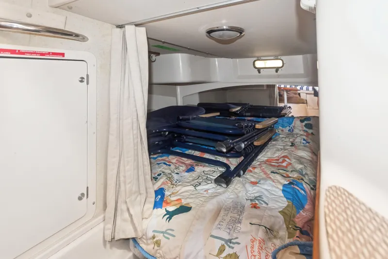 Pole Position Yacht Photos Pics 2006 Grady-White Express 330 cabin interior with colorful bedding and folded chairs.