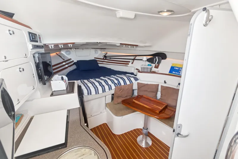 Pole Position Yacht Photos Pics 2006 Grady-White Express 330 cabin interior with bed, seating, and wooden table.