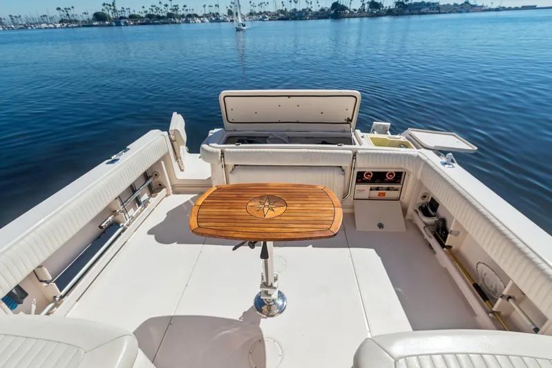 Pole Position Yacht Photos Pics 2006 Grady-White Express 330 boat interior with wooden table, docked on calm water.