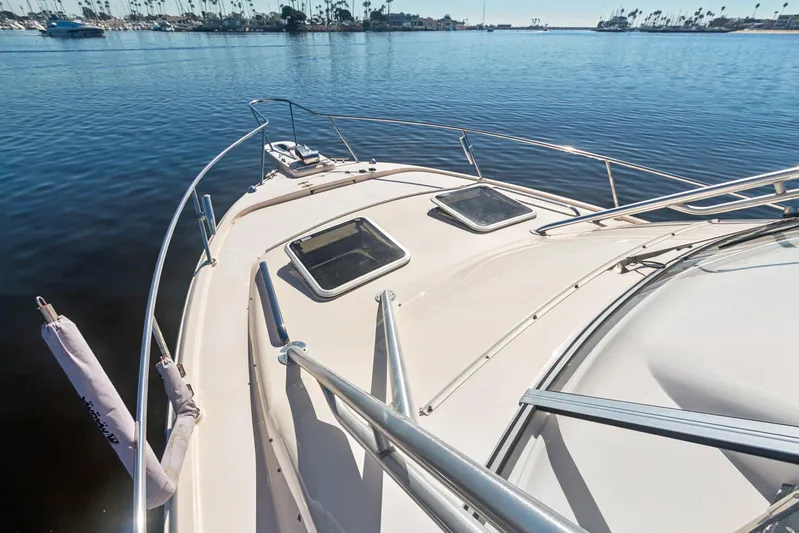 Pole Position Yacht Photos Pics 2006 Grady-White Express 330 boat deck on calm water, marina in background.