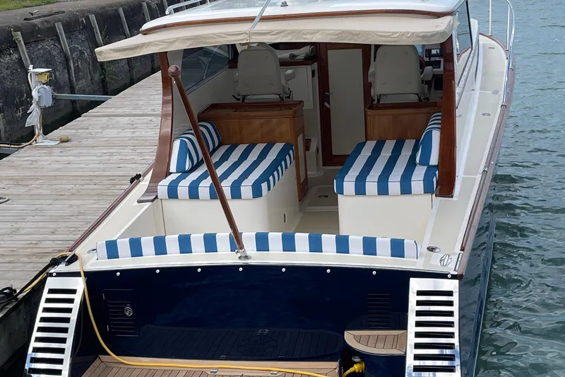  Yacht Photos Pics 2006 Marlow 375 Prowler Classic boat with striped seating, docked at a marina.