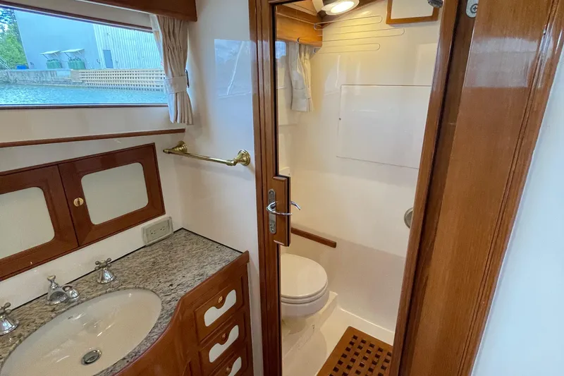 Yacht Photos Pics Bathroom interior of 2006 Marlow 375 Prowler Classic yacht, featuring wood accents and granite countertop.