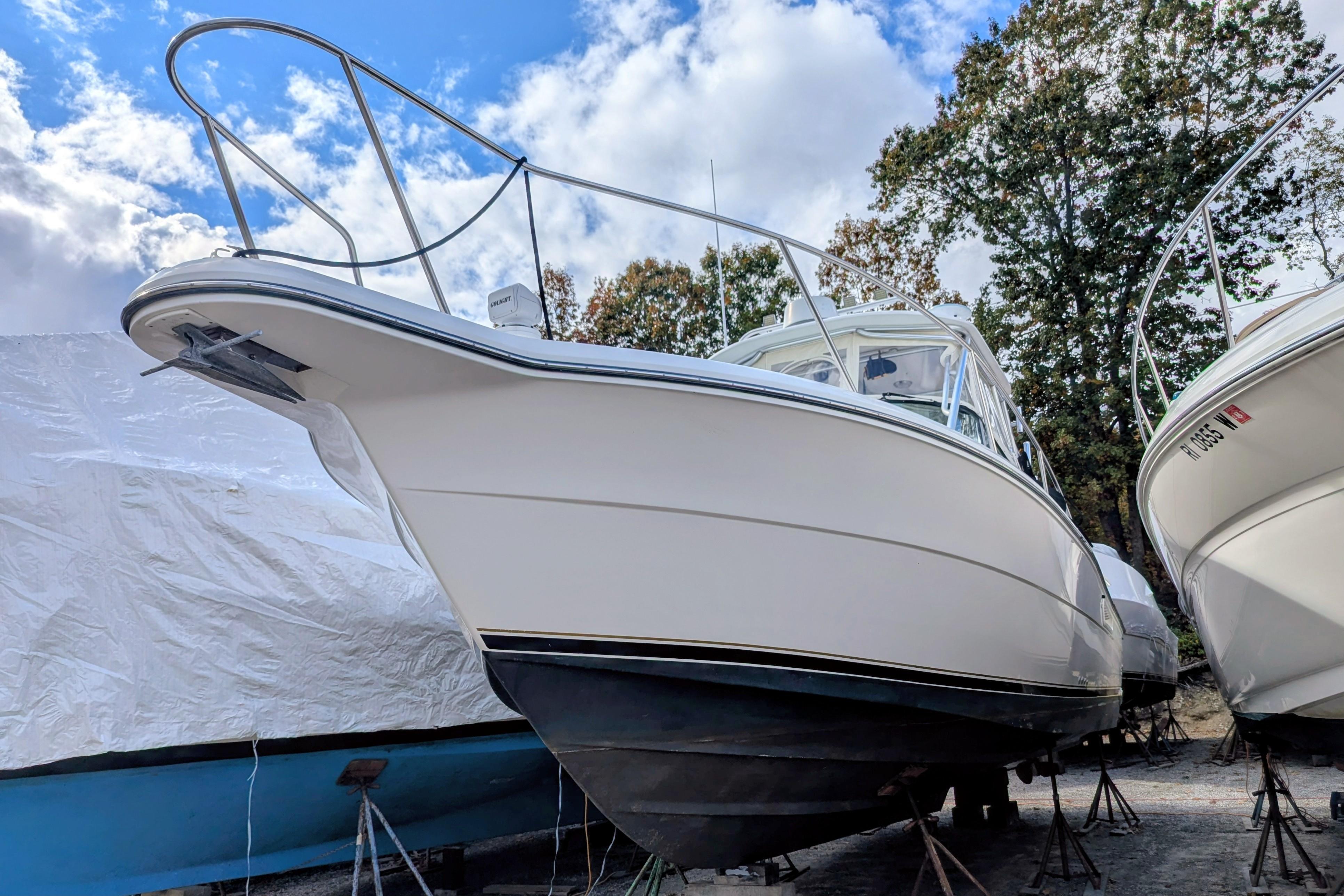 2002 Stamas 340 Express boat on stands, under a partly cloudy sky.