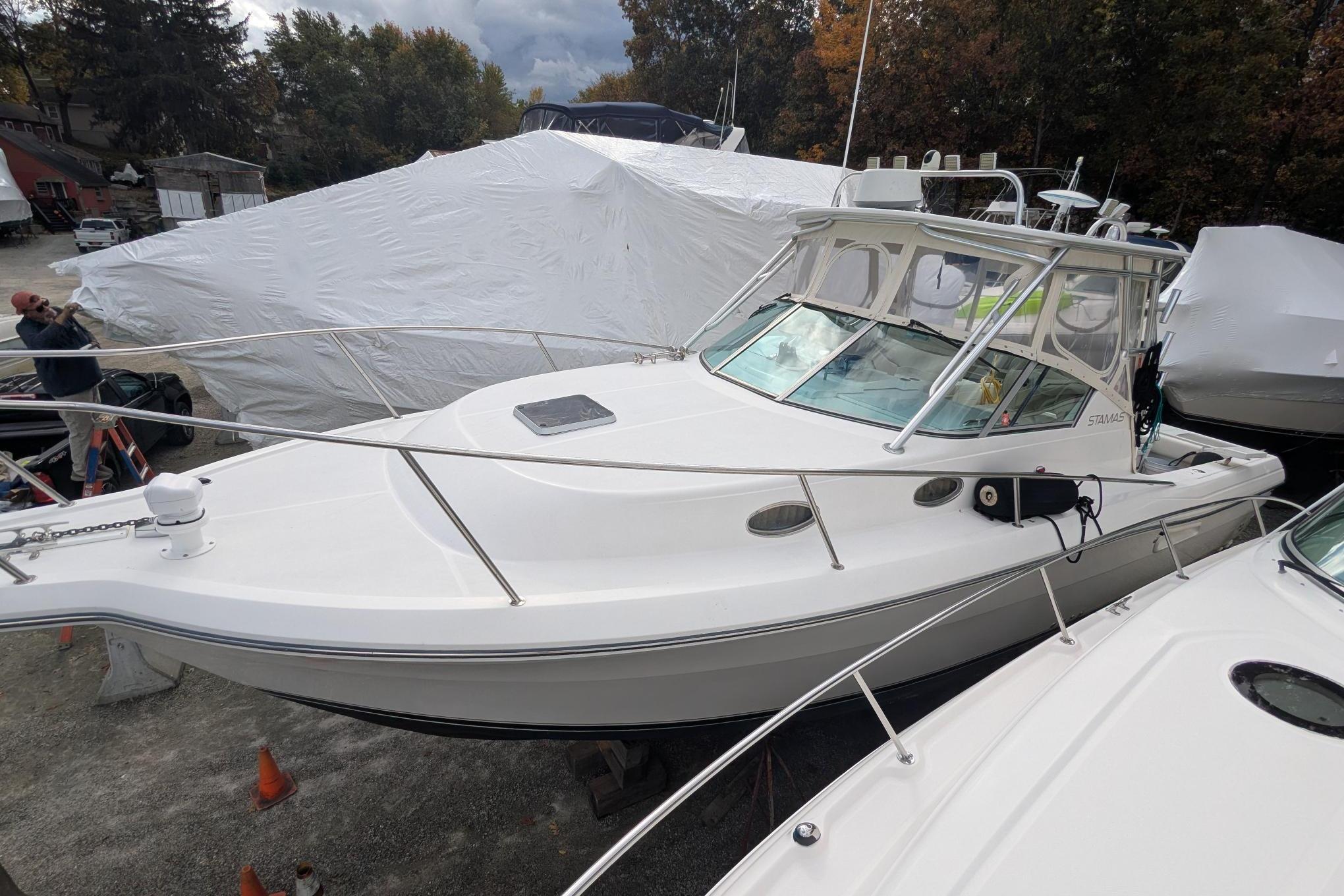 2002 Stamas 340 Express boat in storage, covered and ready for maintenance.