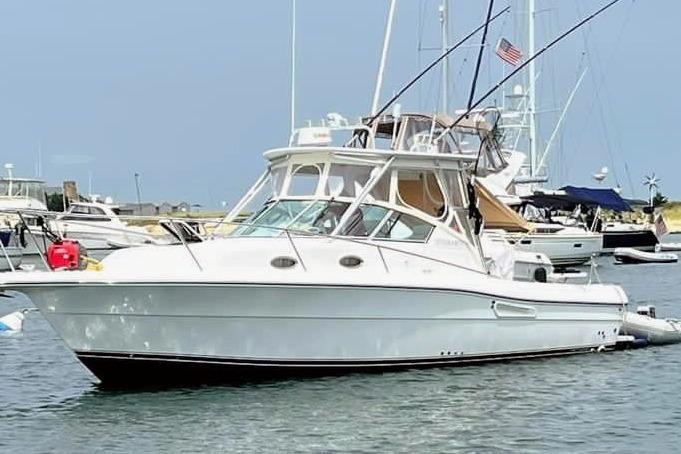 2002 Stamas 340 Express boat docked in a marina, featuring a sleek white design.
