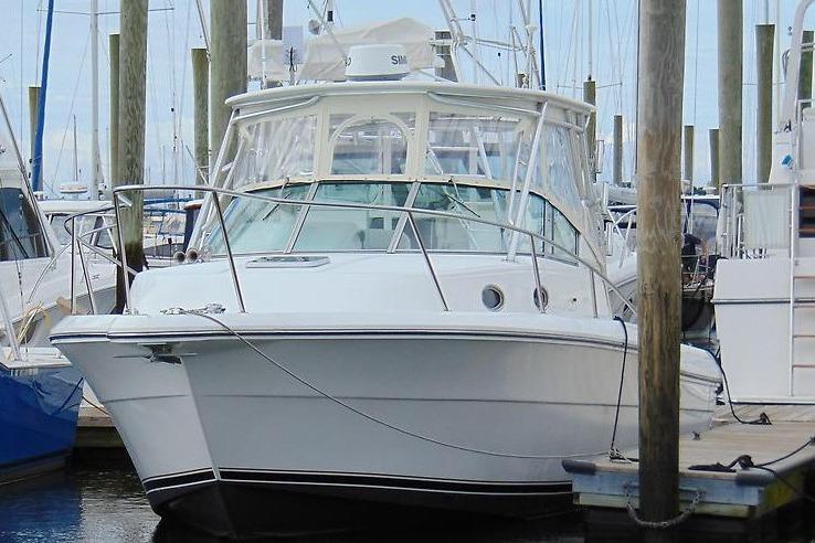 2002 Stamas 340 Express boat docked at marina with clear skies.