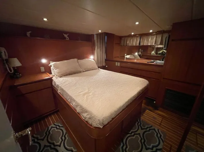 The Lucky Dreamers Yacht Photos Pics Luxurious bedroom interior of 2005 Novatec 48 Cockpit Motor Yacht with wood paneling.