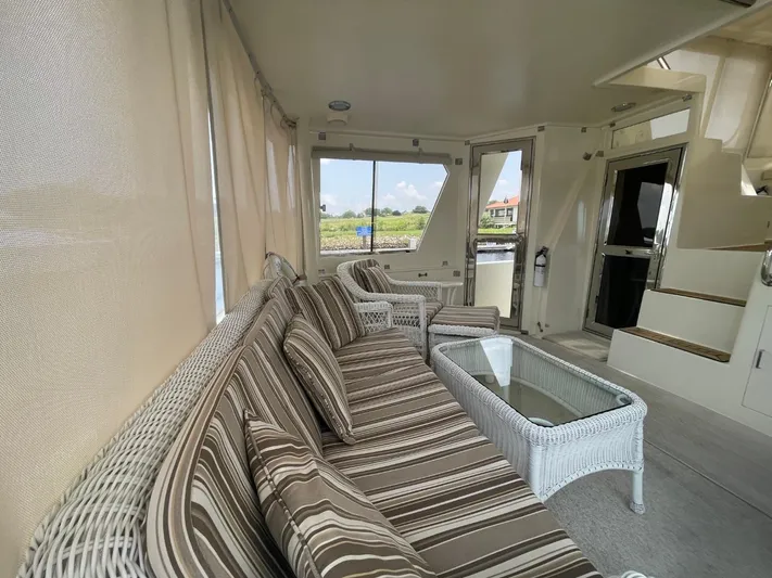 The Lucky Dreamers Yacht Photos Pics Luxurious 2005 Novatec 48 Cockpit Motor Yacht interior with striped seating and glass table.