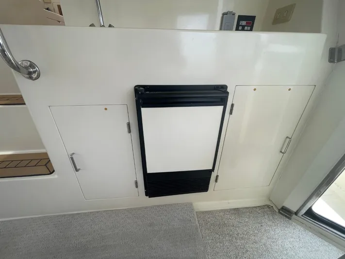 The Lucky Dreamers Yacht Photos Pics Interior of 2005 Novatec 48 Cockpit Motor Yacht with storage compartments and a mini fridge.