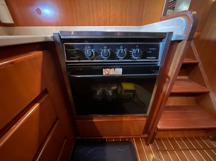 The Lucky Dreamers Yacht Photos Pics 2005 Novatec 48 Cockpit Motor Yacht kitchen with a built-in oven and wooden cabinetry.