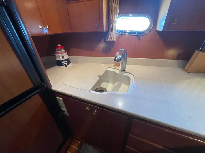 The Lucky Dreamers Yacht Photos Pics 2005 Novatec 48 Cockpit Motor Yacht kitchen with sink, cabinets, and porthole window.