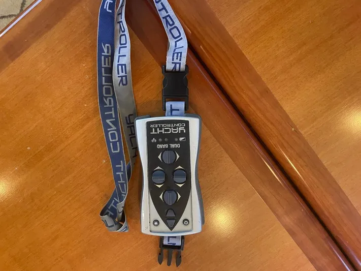 The Lucky Dreamers Yacht Photos Pics Remote control for Novatec 48 Cockpit Motor Yacht, 2005, on wooden surface.